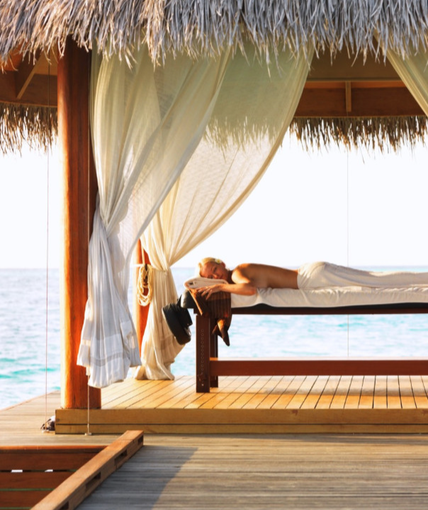 Person relaxing on a deck by the sea.