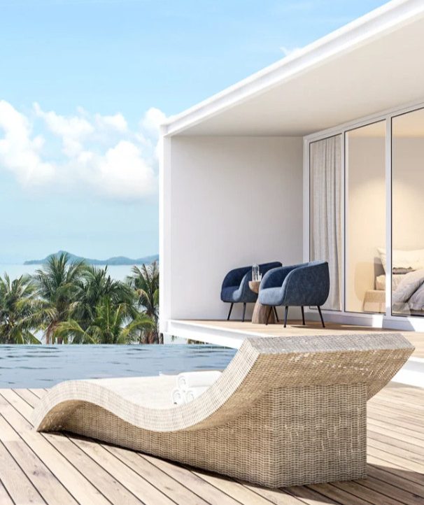 Luxury lounge area with ocean view and palm trees.