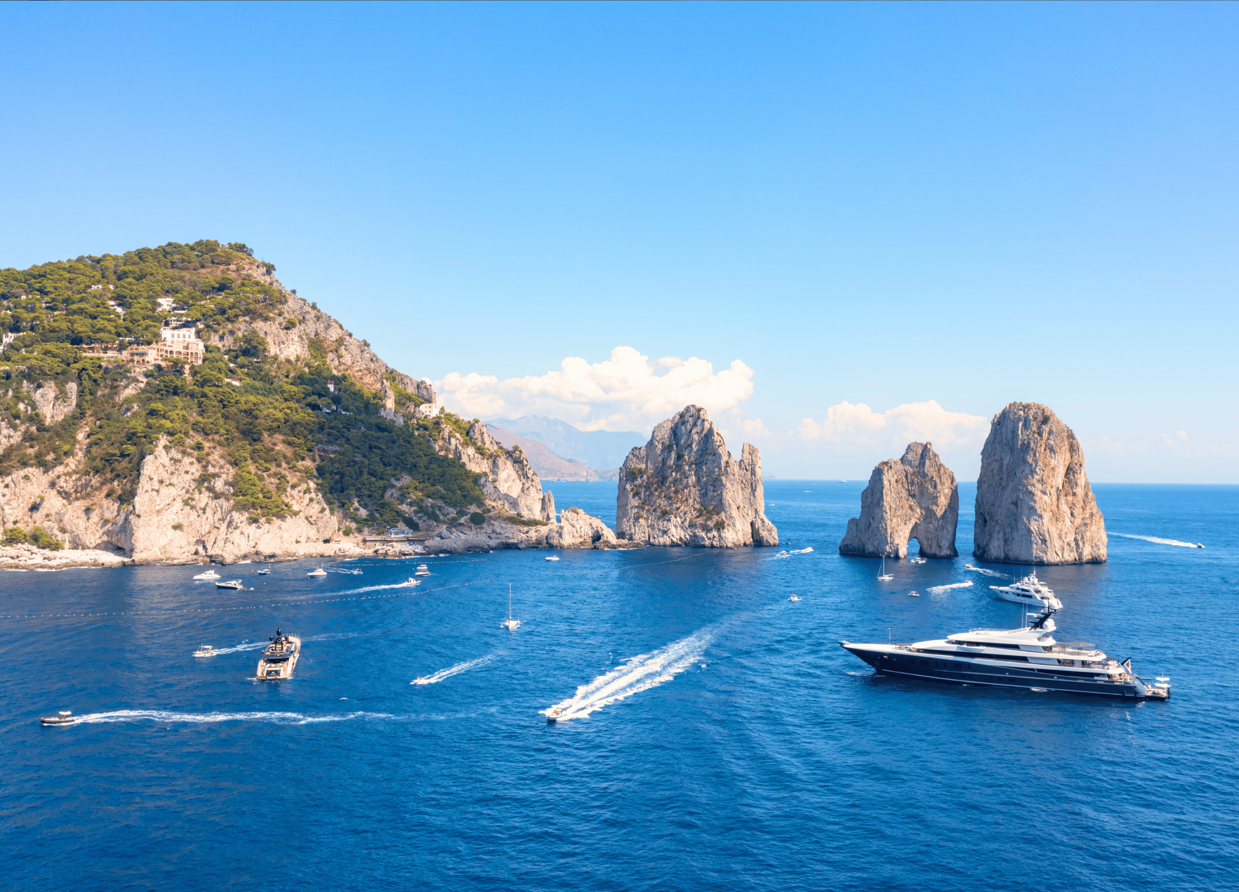 Capri coastline with boats and rock formations.