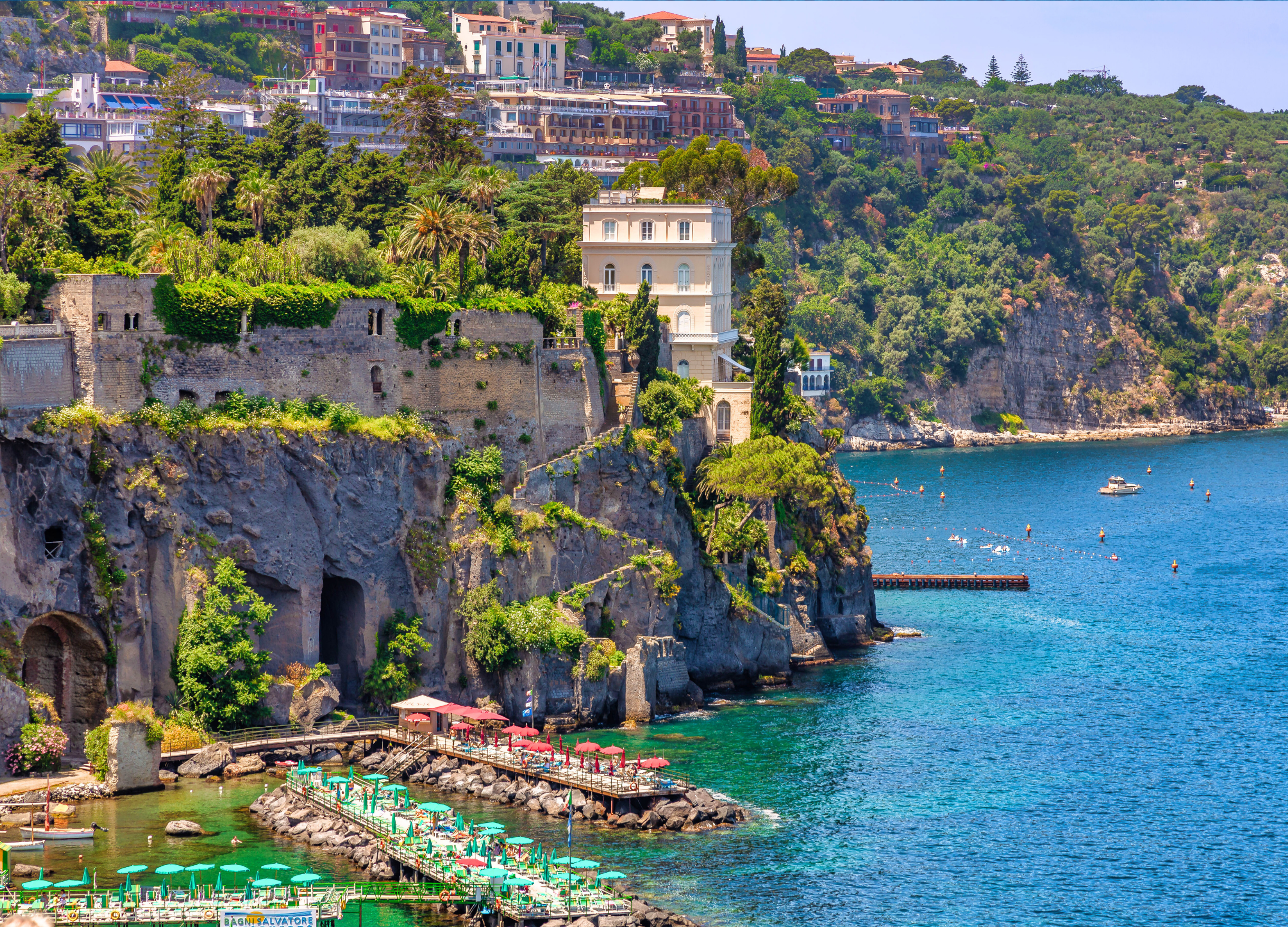 Scenic coastal cliff view with seaside buildings.
