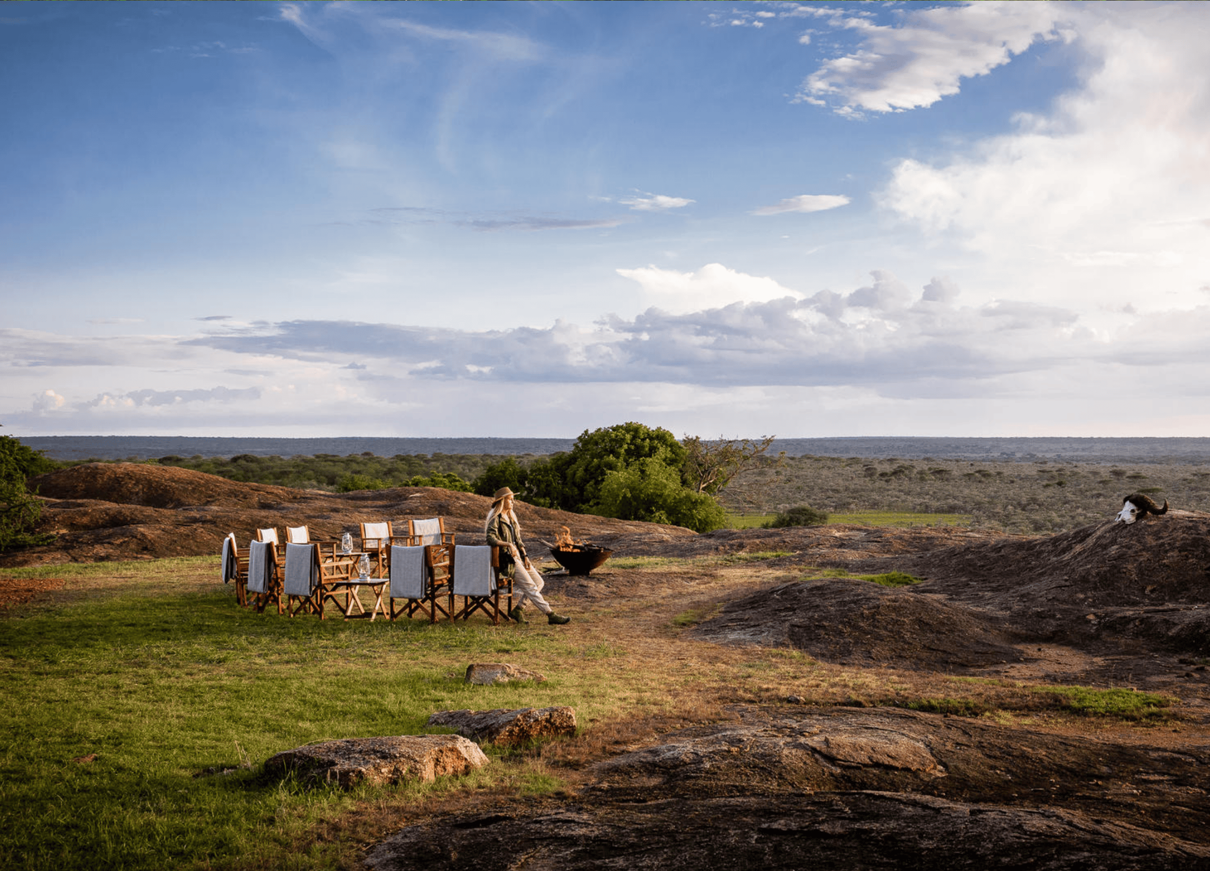 Outdoor dining setup on serene grassy landscape.