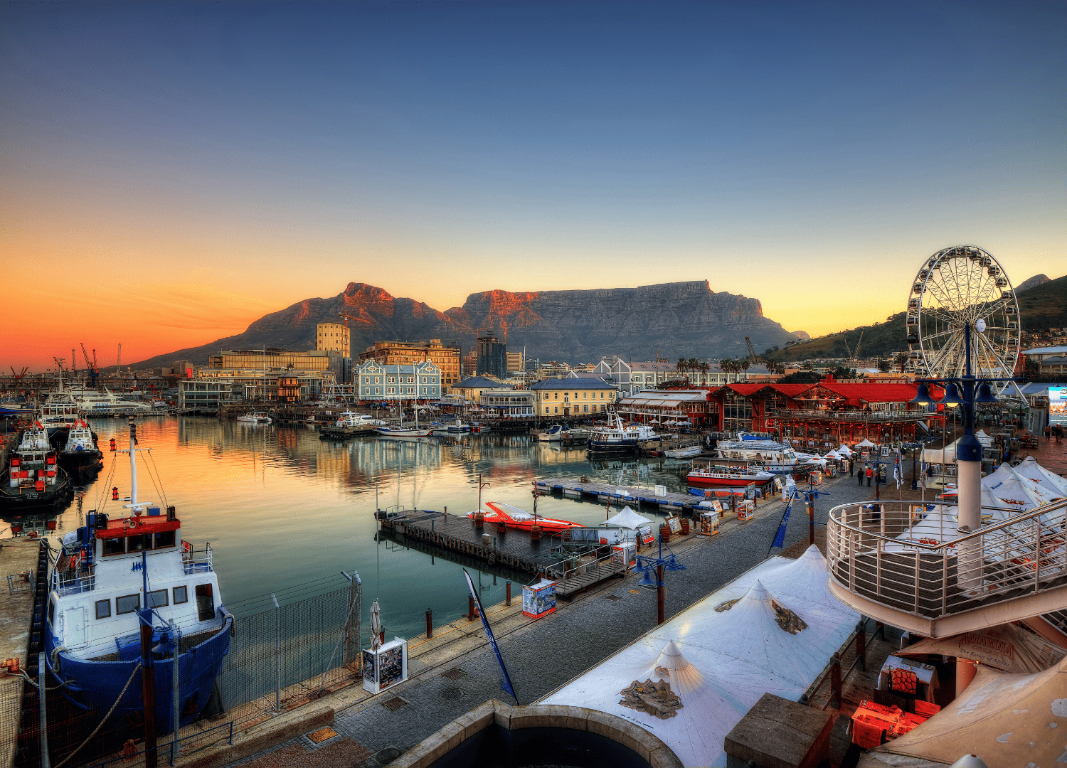 Cape Town harbor with Table Mountain backdrop at sunset.