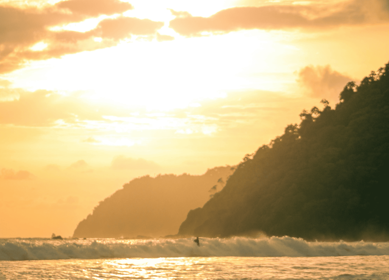 Sunset over ocean waves and mountain