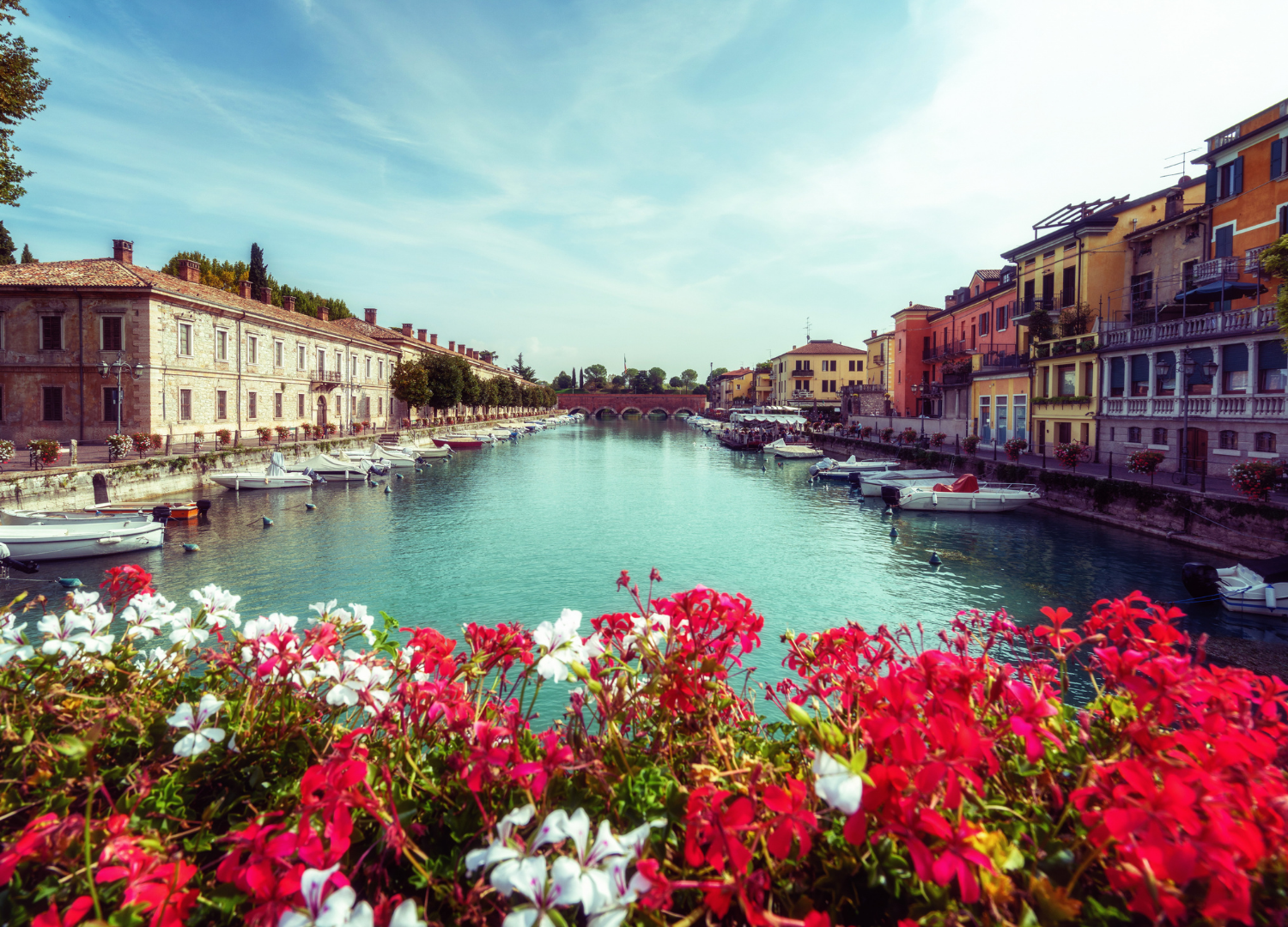 Colorful canal with boats and vibrant flowers