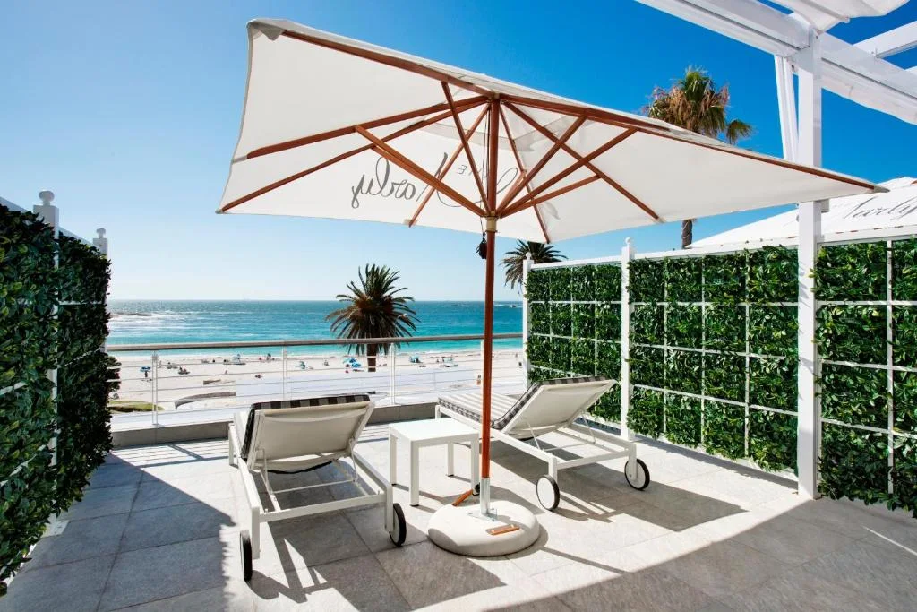 Beachfront patio with loungers and umbrella view.