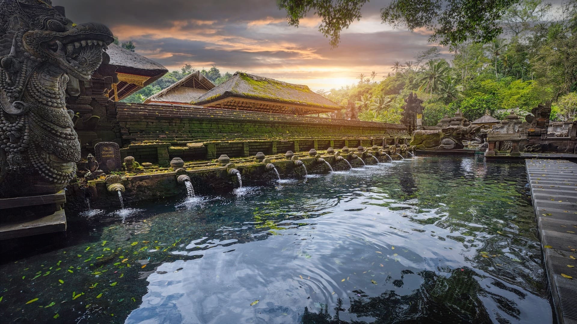 Balinese temple with water fountains at sunset.